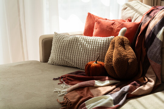 Cozy Autumnal Scene Sofa With Pumpkins Cushions And Warm Plaid Blanket Inviting Seasonal Comfort And Relaxation