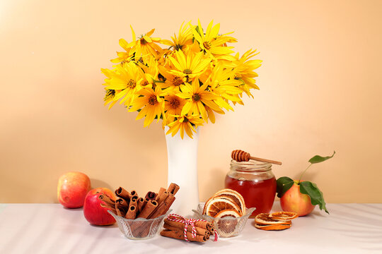 Autumn greeting and gratitude concept. Autumn banner with a beautiful bouquet of rudbeckia in a vase, honey, apples, dried orange, cinnamon and star anise on an elegant gradient background