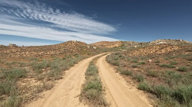 Forward movement along a dry dirt road in hills