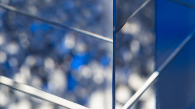 Abstract blue glass panels with reflective bokeh background