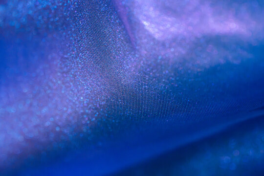Abstract blue and purple fabric texture with luminous shimmer