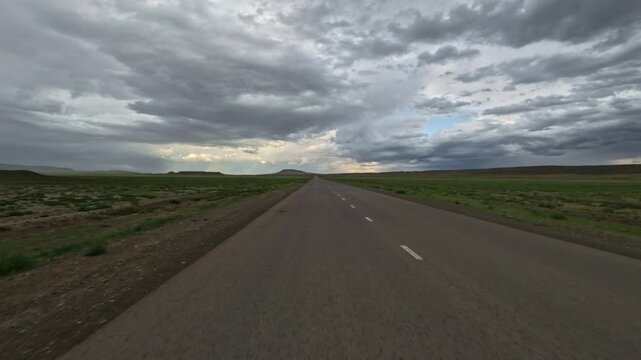 Driving forward on a paved road through flat terrain