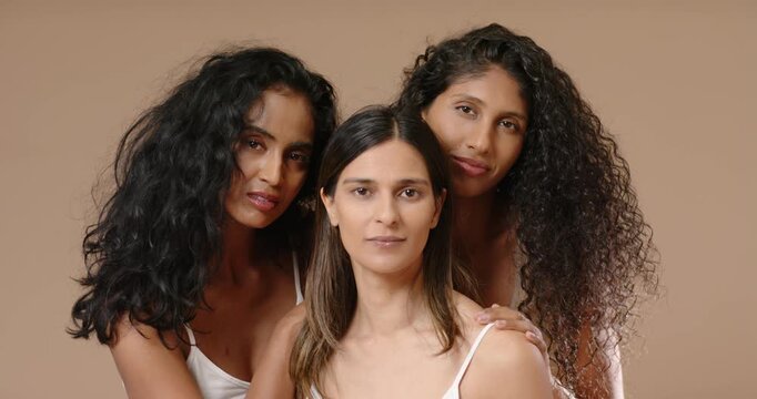 Diverse female models wearing white camisoles posing in studio, responding to photographer cues