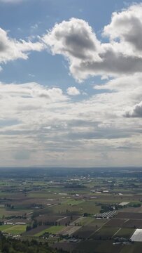 Panoramic Aerial View of Fraser Valley Farmland and Fields in Chilliwack, British Columbia, Canada Under a Cloudy Sky