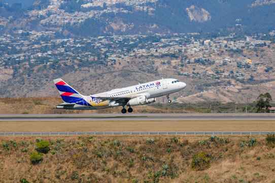 A LATAM Airbus A319 jet, sporting the special livery of the Ecuadorian national team, takes off powerfully from the runway at Mariscal Sucre Airport, soaring above the arid Andean landscape of Quito.