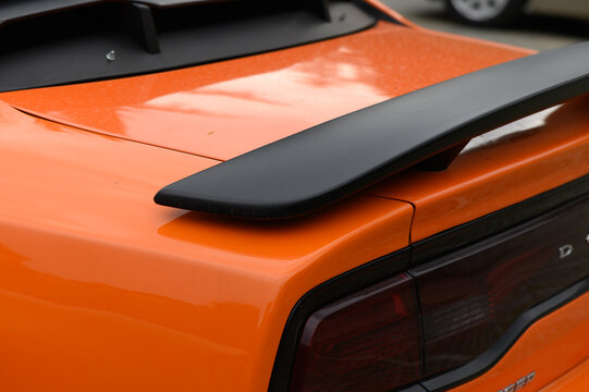 Commercial stock photo of a modern orange sports car rear spoiler detail
