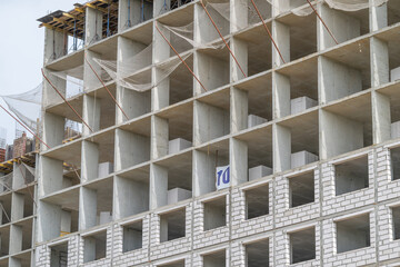 Construction workers progress on a modern building showcasing unique architecture and structure in the heart of the city during early afternoon hours © beholdereye
