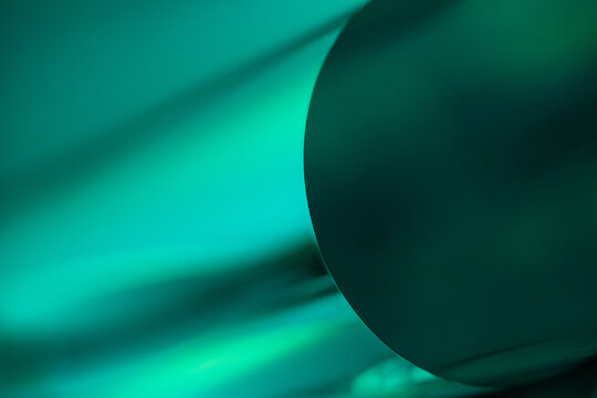 Abstract teal light and shadow on curved dark surface