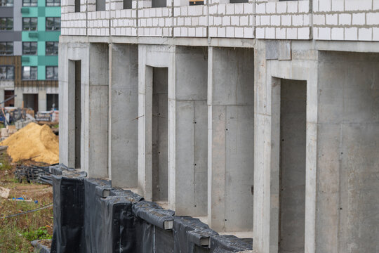 Construction progress on a modern building reveals concrete structures in a bustling urban area surrounded by green spaces