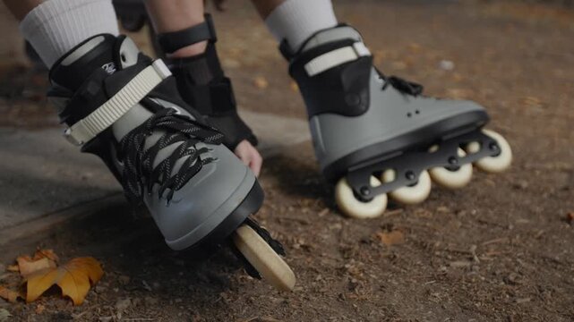 Rollerblader resting on a bench with his skates in a park