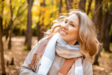 Obraz premium Joyous woman catching autumn wind outdoors — feeling ultimate life satisfaction. Self care concept and joyful loneliness appreciation. Free female person breathing fresh air in beautiful fall.