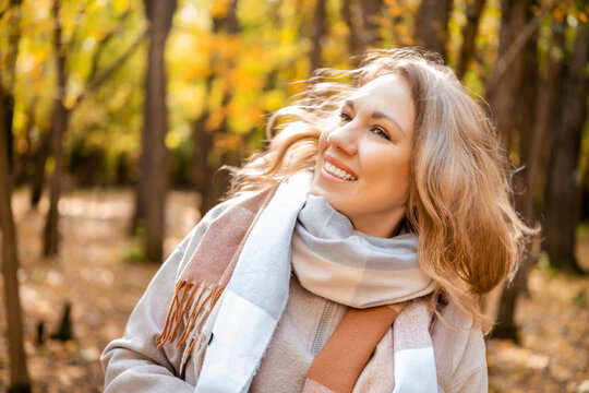 Joyous woman catching autumn wind outdoors &mdash; feeling ultimate life satisfaction. Self care concept and joyful loneliness appreciation. Free female person breathing fresh air in beautiful fall.