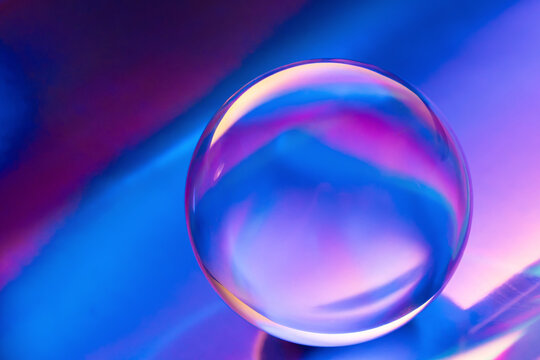 Abstract glass sphere with neon blue and purple reflections