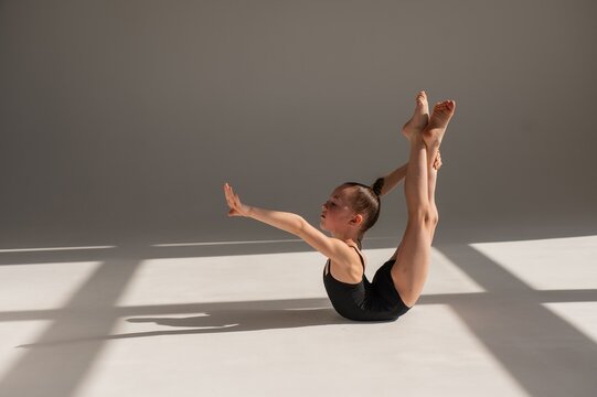 Little gymnast posing on a white background. 