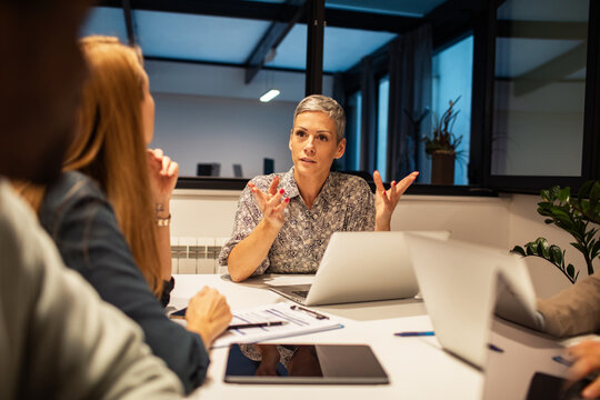 Confident female manager leading team discussion in modern office