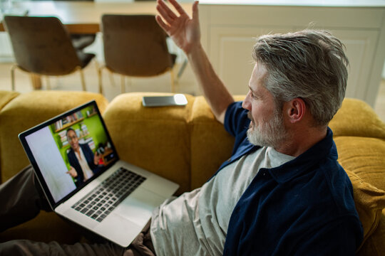 Mature man on laptop video call at home
