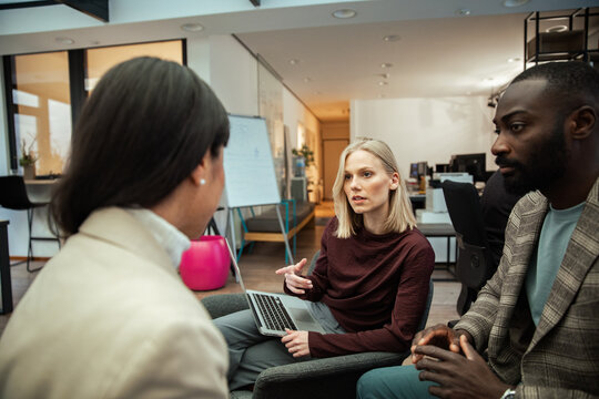 Colleagues discussing project strategy in modern office