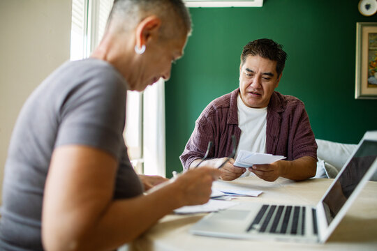 Mature couple reviewing household bills at home