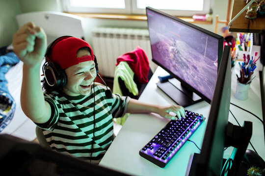 Happy child wearing headset playing video game at home