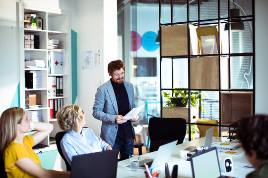Coworkers discussing project in modern office