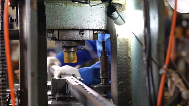 Industrial Press Machine Metalworking Workshop Factory Worker Operating Machinery, Metal Stamping Equipment Shaping Steel Components with Focused Manufacturing Precision and Gloved Worker Handling