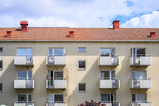 Traditional apartment facade with balconies and red tiled roof.