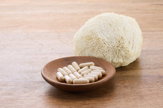 Lion's mane mushroom and capsules on wooden table