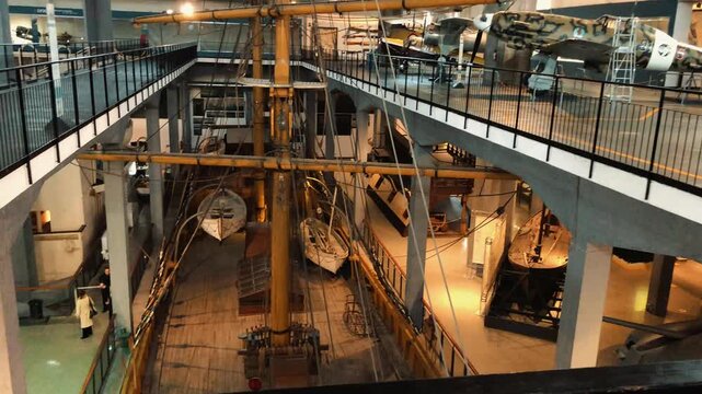 High-angle view of the historic wooden deck, rigging, and masts of the sailing ship Ebe preserved inside the naval pavilion at Milan Science Museum in Italy.

