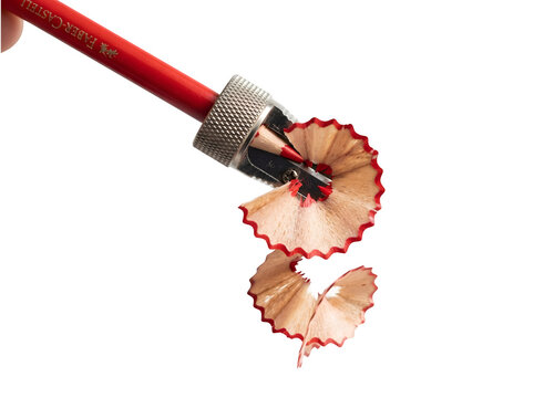 A red fabercastell pencil being sharpened with a metal sharpener isolated on transparent background