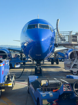 BURBANK, CA, APR 28, 2026: Close-up front view of Southwest Airlines Boeing 737 nose with air stairs deployed, tow tug with steering wheel in foreground, mountains visible under blue sky, Burbank Airp