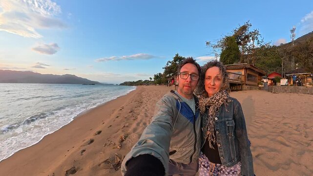 Happy Couple Enjoying a Romantic Sunset on a Beautiful Beach in Ilhabela, Brazil