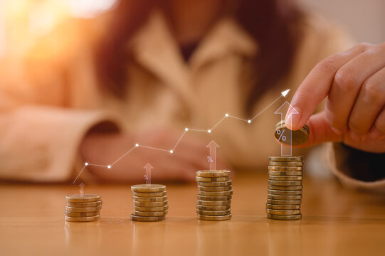 Saving money concept. Young girl's hand put coin on coins stack. Financial growth, investment, wealth management, budgeting, economic planning and longterm stability for personal finance success.