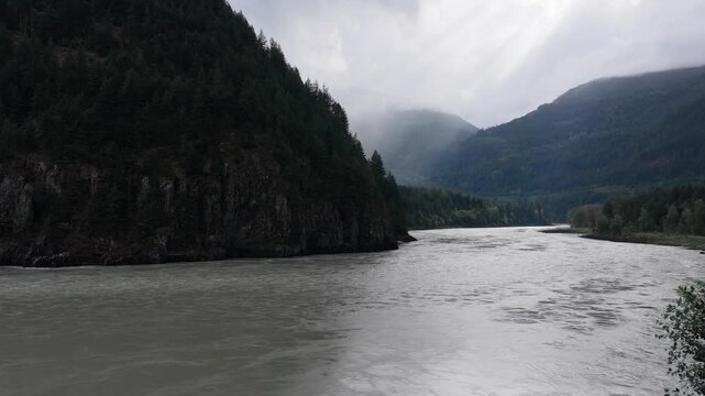 Scenic River Flowing Through Lush Green Forests and Majestic Mountains in British Columbia, Canada