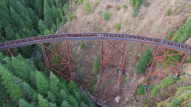 Aerial View of Historic Railway Trestle Bridge Spanning a Deep Forest Valley in British Columbia, Canada