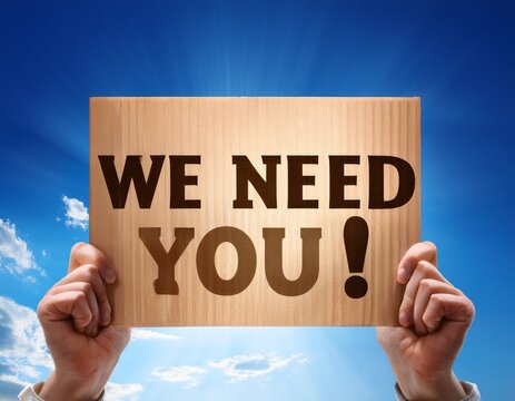 hands holding we need you sign against blue sky