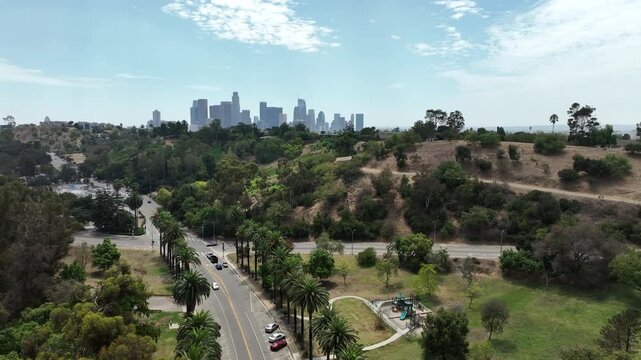 Los Angeles, California, USA - Rising Drone Aerial View From Elysian Park Urban Neighborhood Revealing Downtown LA Skyline and Central LA Cityscape on a Bright Sunny Day