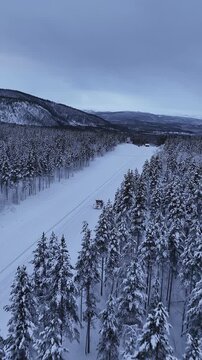 Snowcat grooming cross country ski trails in a winter forest, Norway