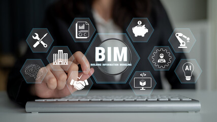 Business professional using computer to manage building information modeling concepts with...