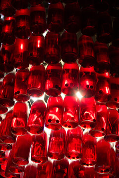 Red bottle chandelier. Glass tincture light fixture. Glowing liquor installation. Ruby alcohol display. Bar pendant lamp design. Craft distillery decor. Berry spirit lamp. Crimson bottle ceiling art