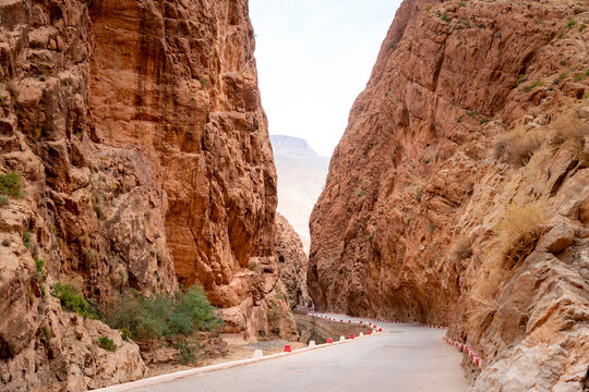 Scenic winding road through towering limestone cliffs of Todra Gorge in Moroccos High Atlas Mountains showcasing dramatic arid canyon landscape ideal for travel and adventure