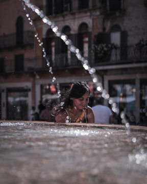 Woman cooling off beside a fountain in Verona, Italy