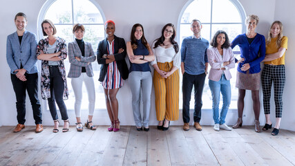Fototapeta premium Diverse group of men and women standing together in a bright studio