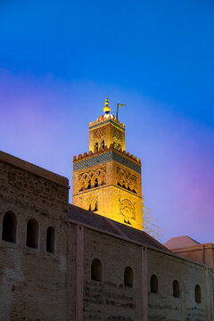 Koutoubia Mosque minaret illuminated against a vibrant twilight sky showcasing traditional Islamic architecture and intricate patterns in the historic city of Marrakech Morocco
