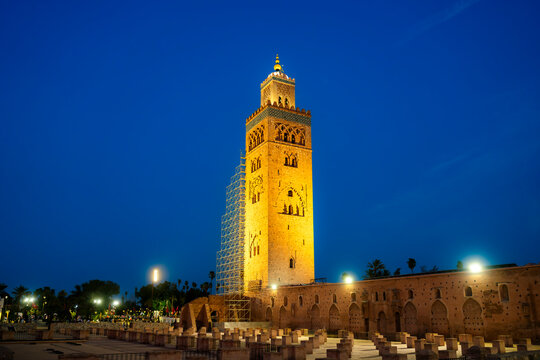 Koutoubia Mosque minaret glowing warmly against the deep blue twilight sky showcasing its iconic architecture and intricate details in Marrakech Morocco a beacon of Islamic culture
