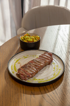 Sliced grilled beef steak served with seasoned potatoes on a plate