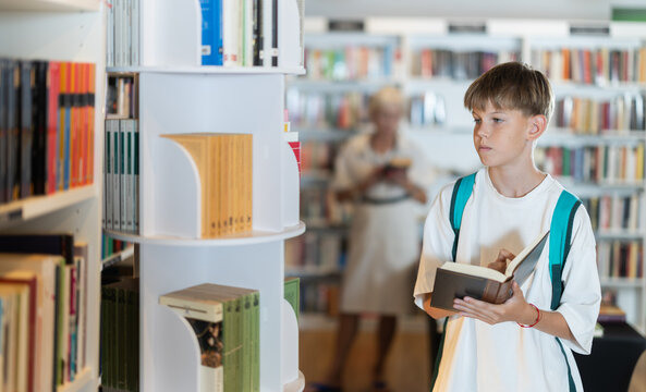 Young male customer explores aisles of bookshop, looking for new story or adventure to read