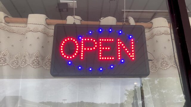 Flashing LED open sign hanging in a storefront window