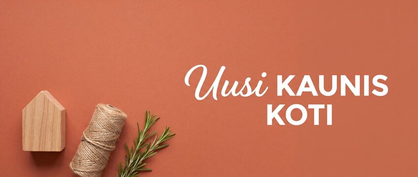 Wooden house toy on terracotta background with Finnish text Uusi Kaunis Koti translating to New Beautiful Home, featuring natural jute twine and fresh rosemary sprig for real estate concept.