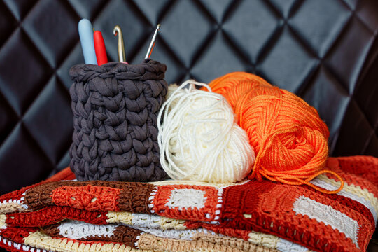Handmade crochet blanket with yarn balls and hooks. Crochet hobby for mental wellbeing, digital detox