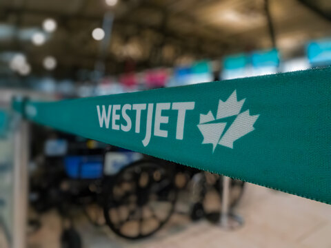Ottawa, Ontario, Canada. Sep 9, 2026. Close-up shallow focus of teal WestJet queue stanchion belt at airport check-in counter area.